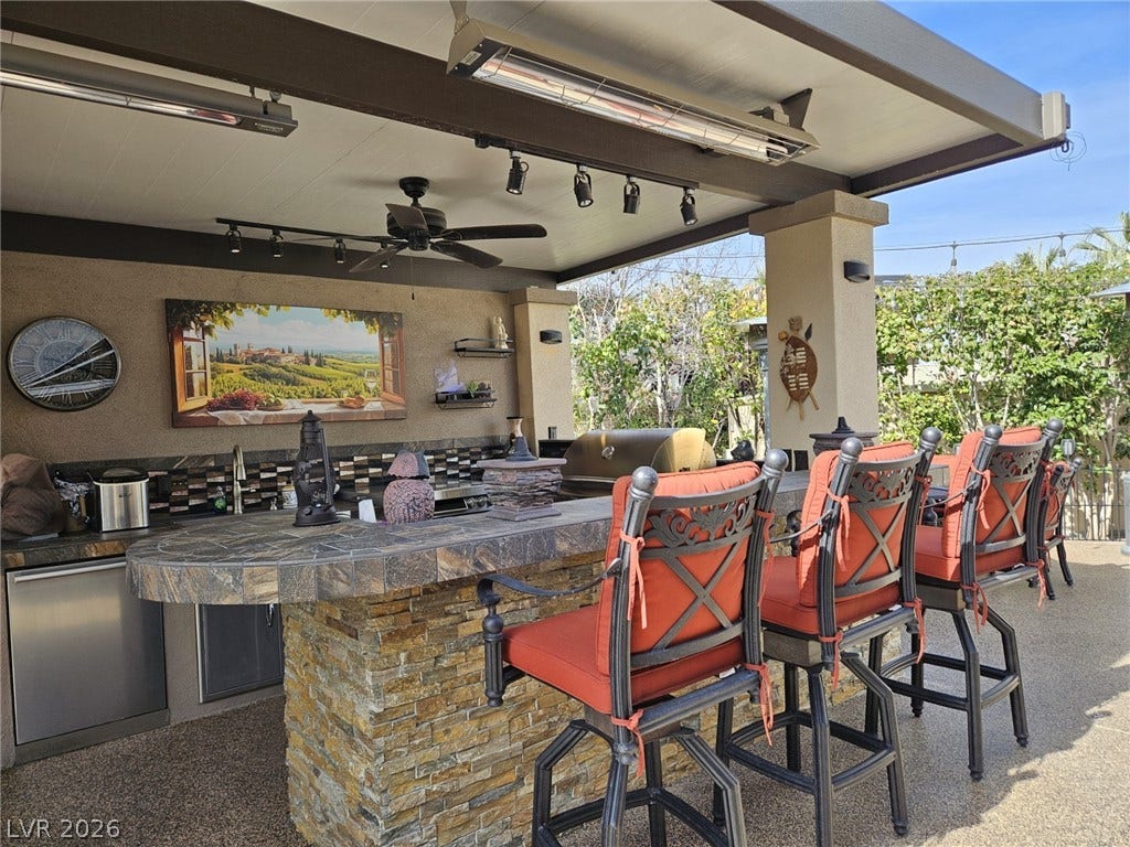 8175 Arville Street, #287, Las Vegas, NV 89139 A fully equipped stone outdoor kitchen and bar area rests under a sheltered patio cover.
