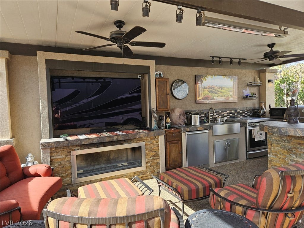 8175 Arville Street, #287, Las Vegas, NV 89139 A fully equipped stone outdoor kitchen and living area sits under a covered patio.