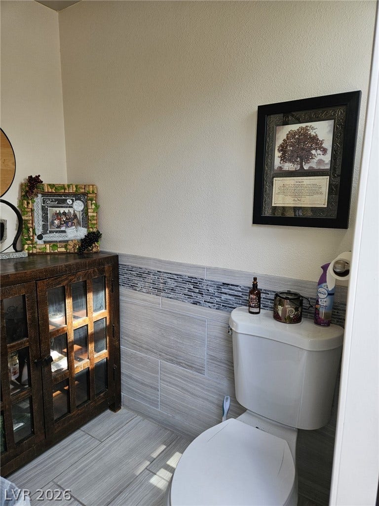 8175 Arville Street, #287, Las Vegas, NV 89139 Elegant tile wainscoting and matching floor tile elevate this half bath design.