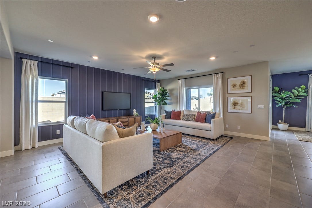1044 Gentle Swan Street, Henderson, NV 89011 An open living space features durable tile flooring and a board and batten accent wall. Photo is of actual model home for sale.