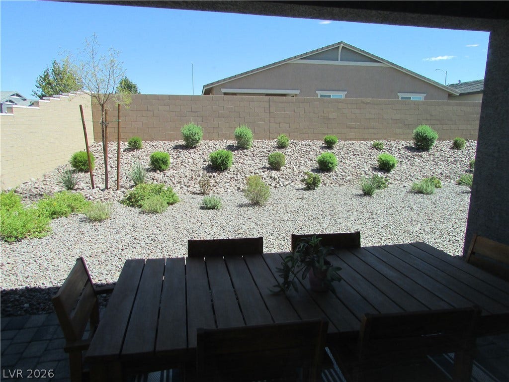 1044 Gentle Swan Street, Henderson, NV 89011 An enclosed covered patio opens directly to a low-maintenance gravel backyard with tiered desert landscaping. Photo is of actual model home for sale.