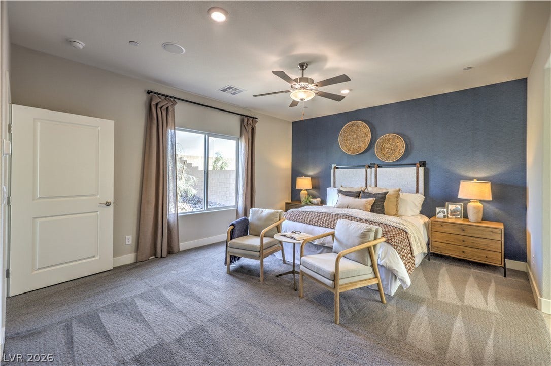 1044 Gentle Swan Street, Henderson, NV 89011 A spacious bedroom offers plush carpeting, recessed lighting, and a large window looking outdoors. Photo is of actual model home for sale.