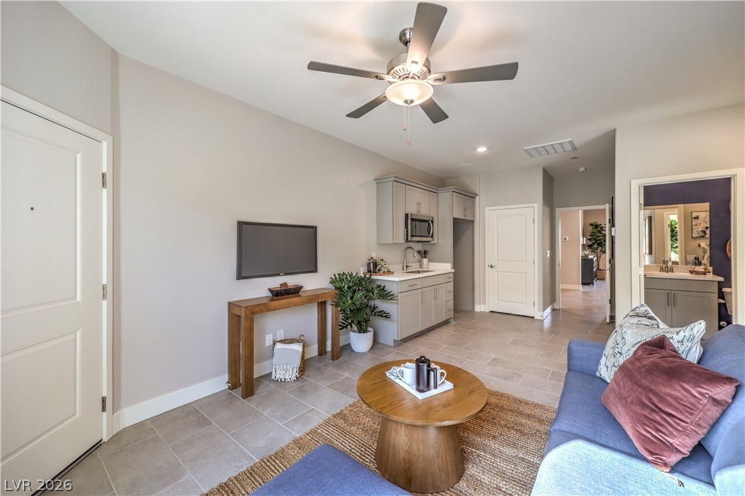 1044 Gentle Swan Street, Henderson, NV 89011 An open-concept living area features clean tile flooring and a functional kitchenette. Photo is of actual model home for sale.