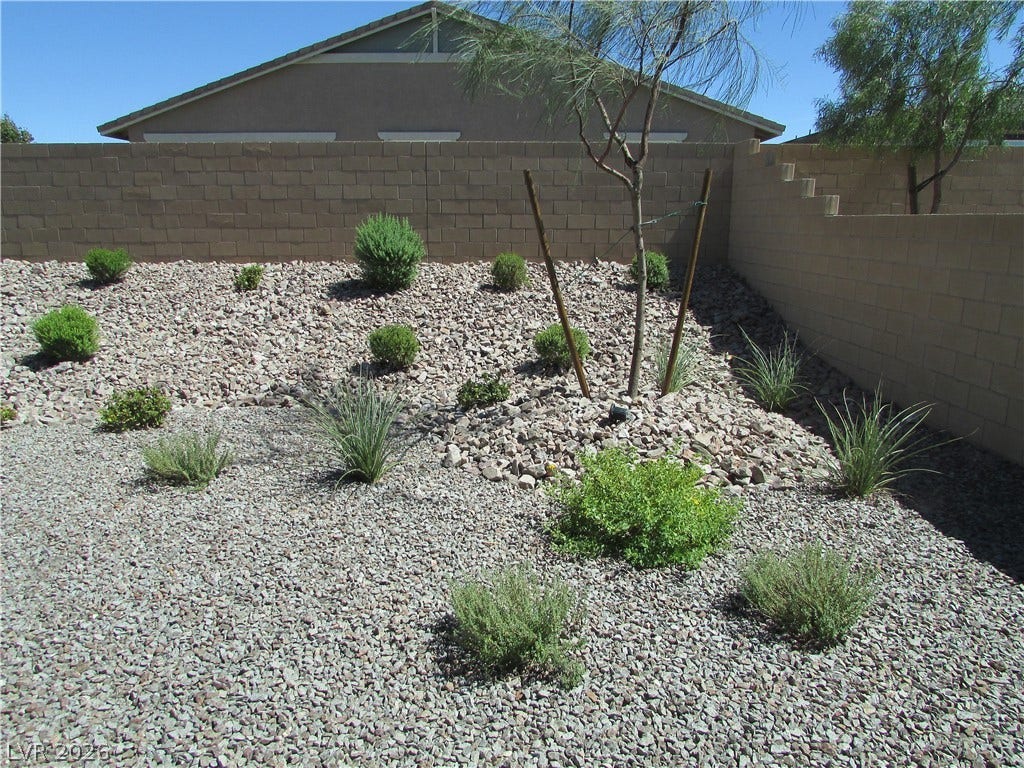 1044 Gentle Swan Street, Henderson, NV 89011 Desert landscaping creates a low-maintenance backyard retreat enclosed by block wall fencing. Photo is of actual model home for sale.