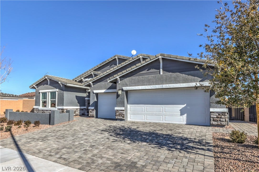 1044 Gentle Swan Street, Henderson, NV 89011 An inviting stone-accented facade fronts this single-story home featuring a paved driveway. Photo is of actual model home for sale.