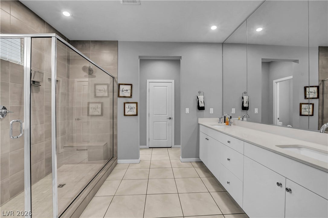 6834 Moorland Street, North Las Vegas, NV 89084 Clean lines and a spacious dual vanity define this modern bathroom with a tiled walk-in shower.