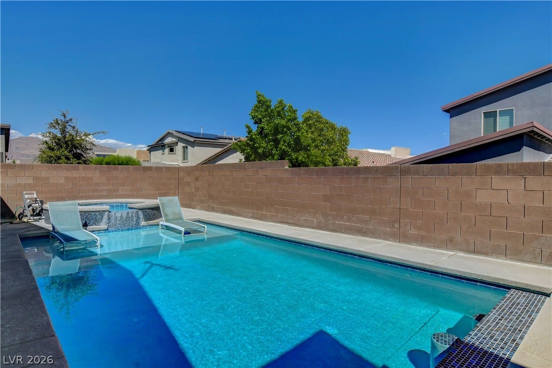 6834 Moorland Street, North Las Vegas, NV 89084 An inviting swimming pool and spa are enclosed by a private block wall under clear skies.
