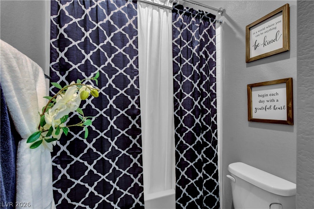 6834 Moorland Street, North Las Vegas, NV 89084 A classic shower and tub combination is framed by neutral-toned walls.