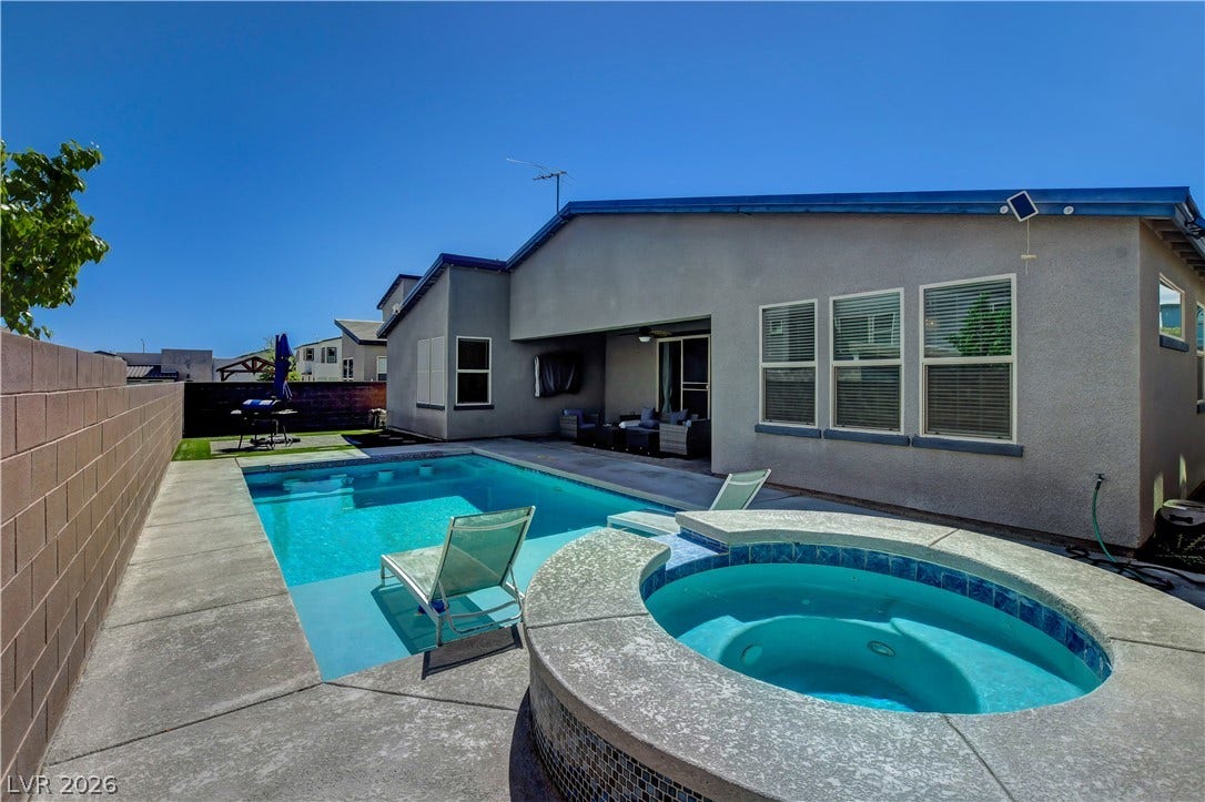 6834 Moorland Street, North Las Vegas, NV 89084 An inviting backyard oasis features a clean stucco exterior alongside a pristine pool and spa.