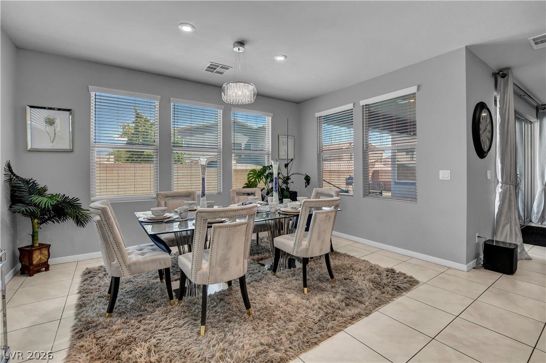 6834 Moorland Street, North Las Vegas, NV 89084 Ample windows invite natural light across the tile flooring of this welcoming dining space.