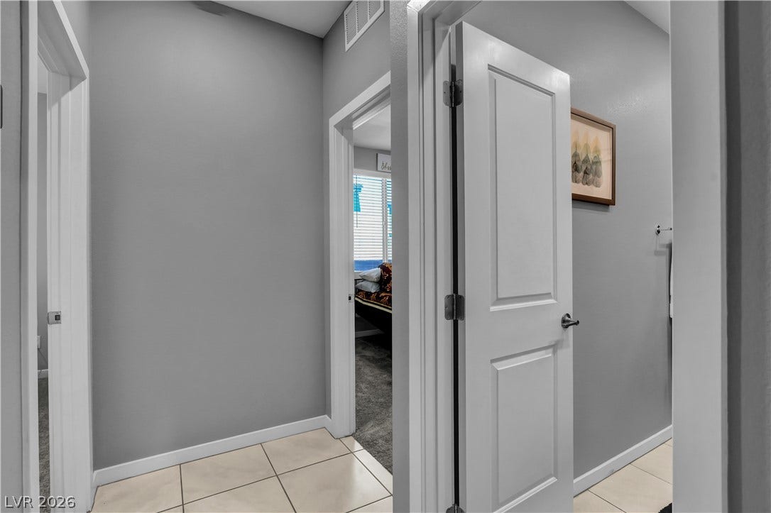 6834 Moorland Street, North Las Vegas, NV 89084 Crisp white trim and matching doors frame this central hallway laid with neutral tile.