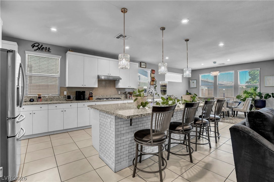 6834 Moorland Street, North Las Vegas, NV 89084 Gleaming tile floors and granite counters define this light-filled culinary space with a large island.