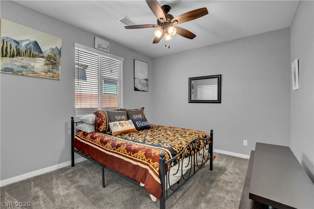 6834 Moorland Street, North Las Vegas, NV 89084 Plush wall-to-wall carpeting and a wide window with integrated blinds highlight this bedroom.