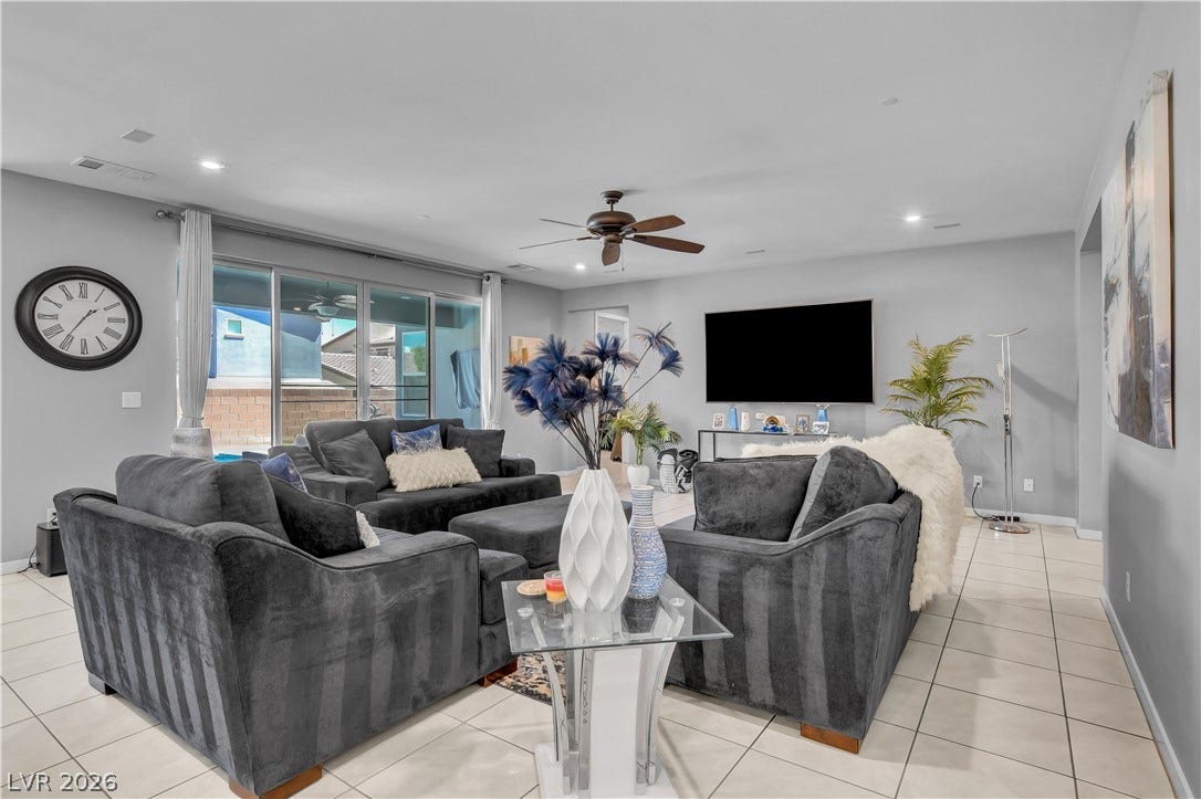 6834 Moorland Street, North Las Vegas, NV 89084 Tiled flooring runs throughout this spacious living area with sliding glass doors opening to the outdoors.
