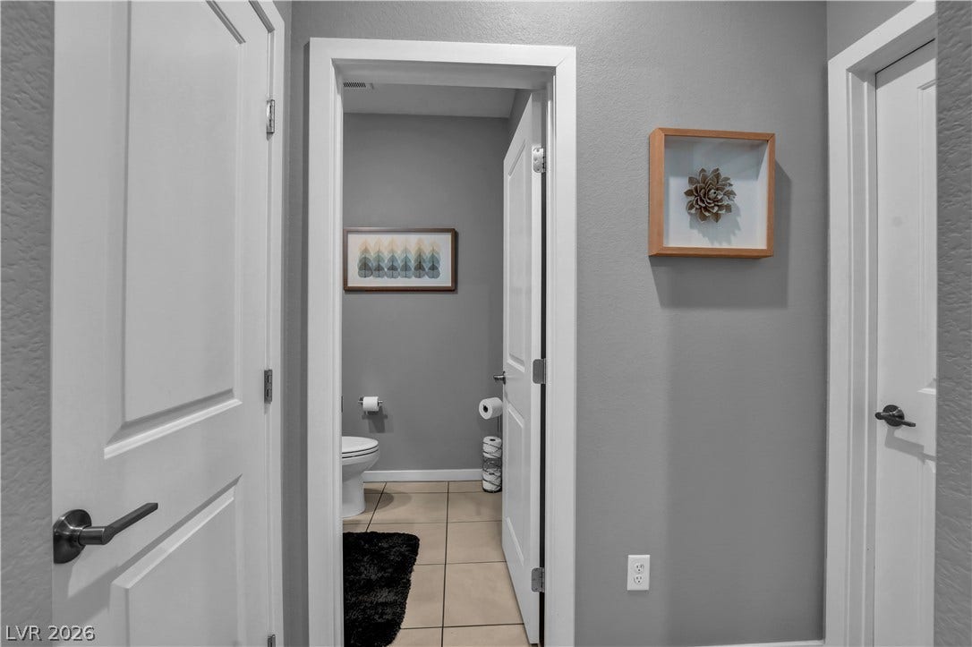 6834 Moorland Street, North Las Vegas, NV 89084 Crisp white trim and tiled floors define this clean hallway leading to a half bath.