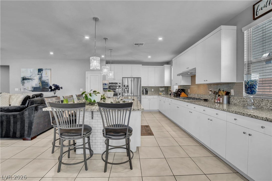 6834 Moorland Street, North Las Vegas, NV 89084 Gleaming tile floors and granite countertops define this modern culinary space.