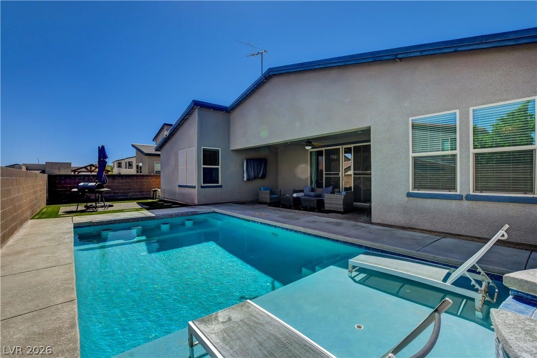 6834 Moorland Street, North Las Vegas, NV 89084 An inviting backyard oasis features a pristine swimming pool alongside a covered concrete patio.