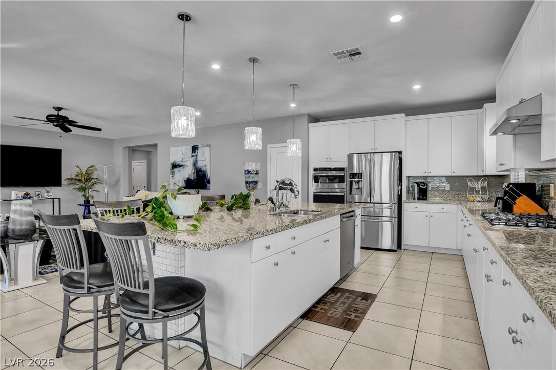 6834 Moorland Street, North Las Vegas, NV 89084 Gleaming stone countertops and matching cabinetry anchor this modern culinary space.