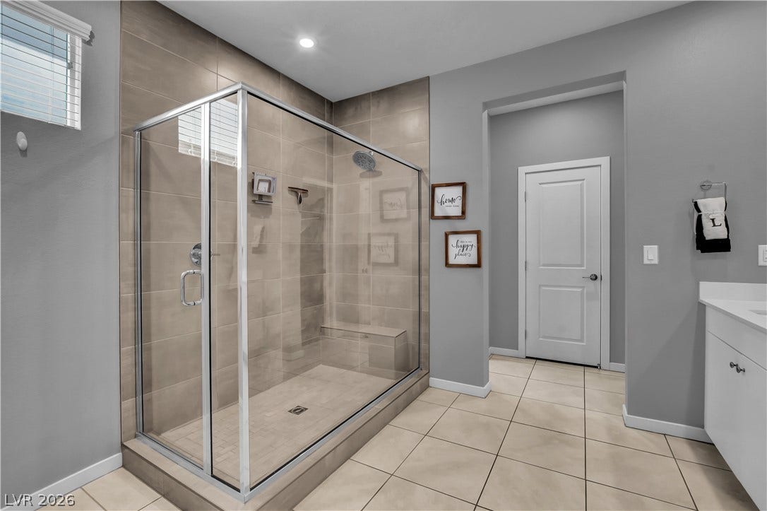 6834 Moorland Street, North Las Vegas, NV 89084 Tiled flooring and a glass-enclosed walk-in shower anchor this master bathroom.
