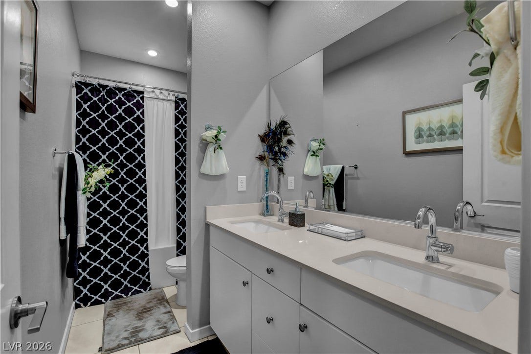 6834 Moorland Street, North Las Vegas, NV 89084 Recessed lighting illuminates a modern vanity with dual undermount sinks and clean-lined cabinetry.