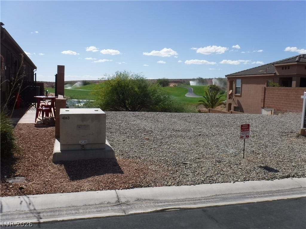 654 Paloma Circle, Mesquite, NV 89027 Expansive fairway views stretch beyond the low-maintenance gravel yard under clear blue desert skies.