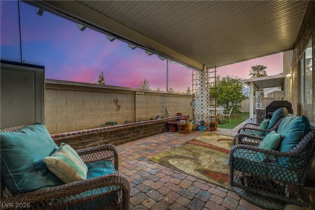 7741 Crenshaw Way, Las Vegas, NV 89129 A spacious covered patio features paver flooring alongside a block-walled backyard.