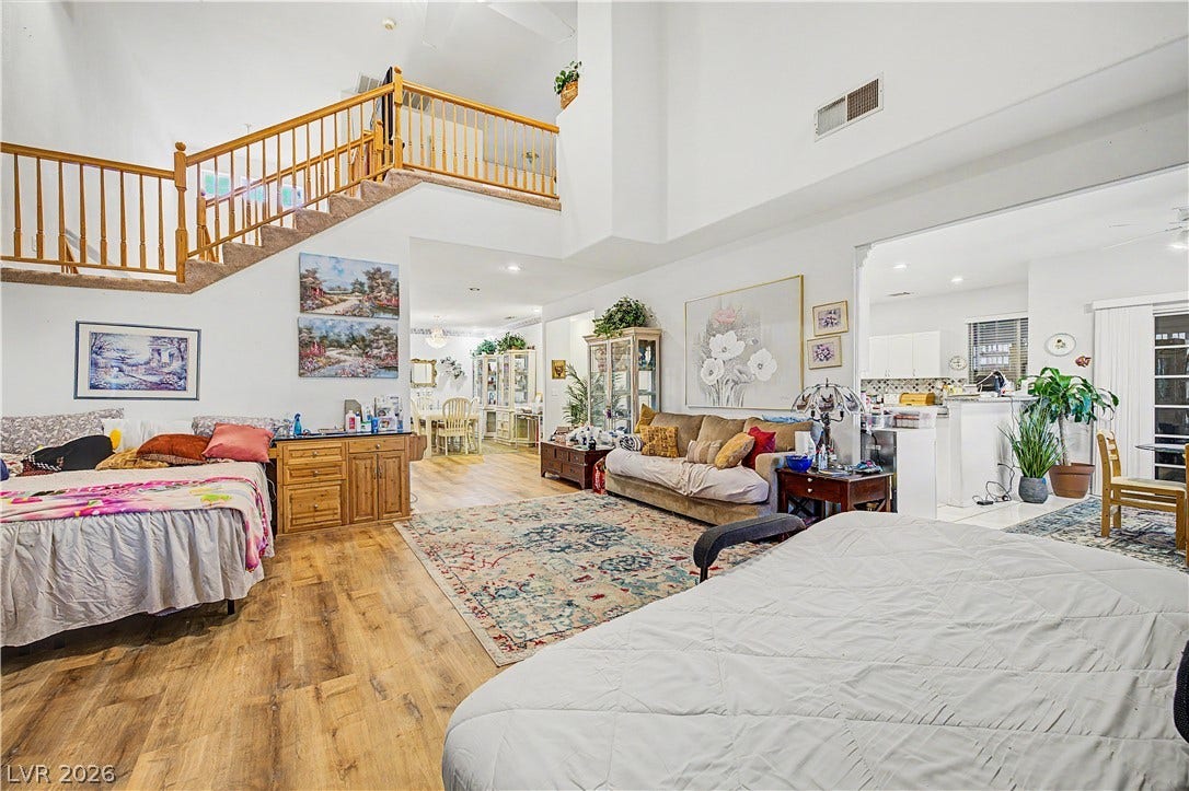 7741 Crenshaw Way, Las Vegas, NV 89129 An open floorplan design anchors this soaring living space featuring hardwood floors and a wooden staircase.