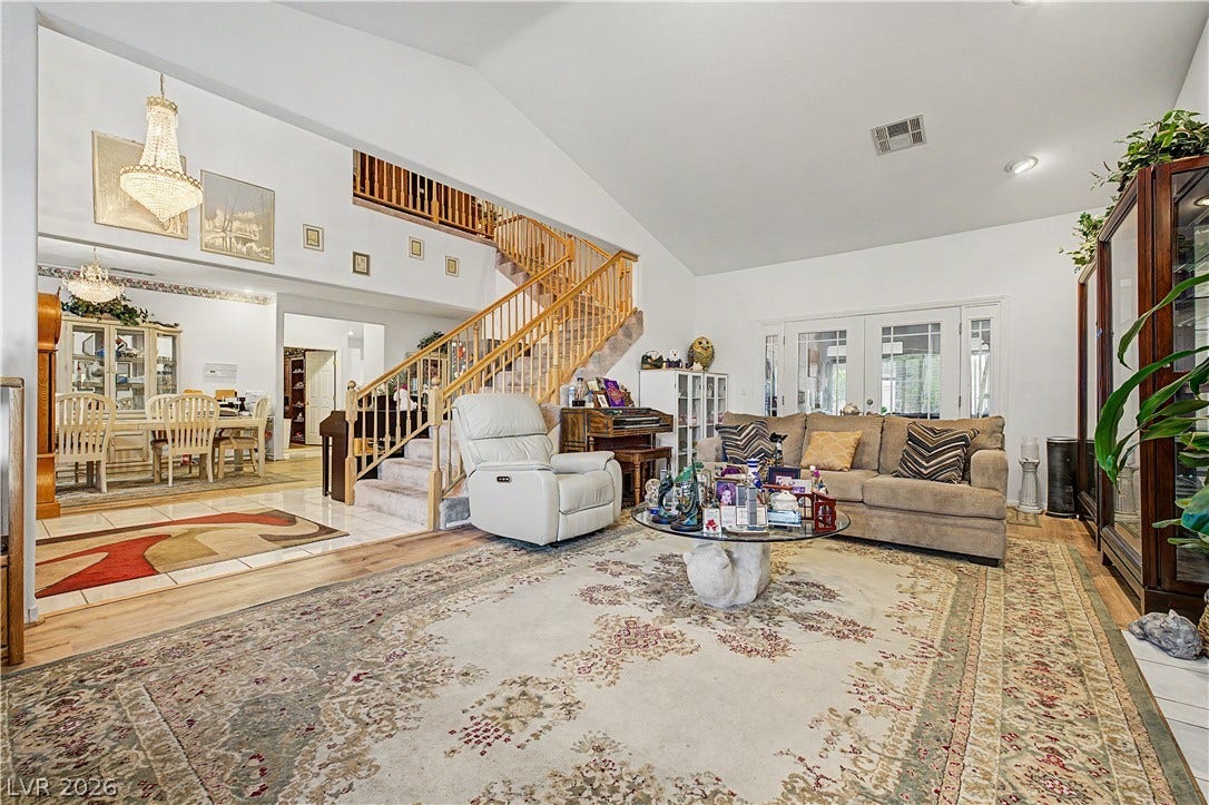 7741 Crenshaw Way, Las Vegas, NV 89129 Soaring vaulted ceilings and a dramatic staircase highlight this open living area.