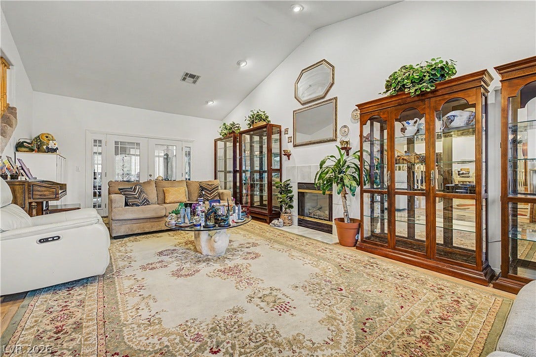 7741 Crenshaw Way, Las Vegas, NV 89129 Vaulted ceilings and a classic fireplace anchor this light-filled living space.