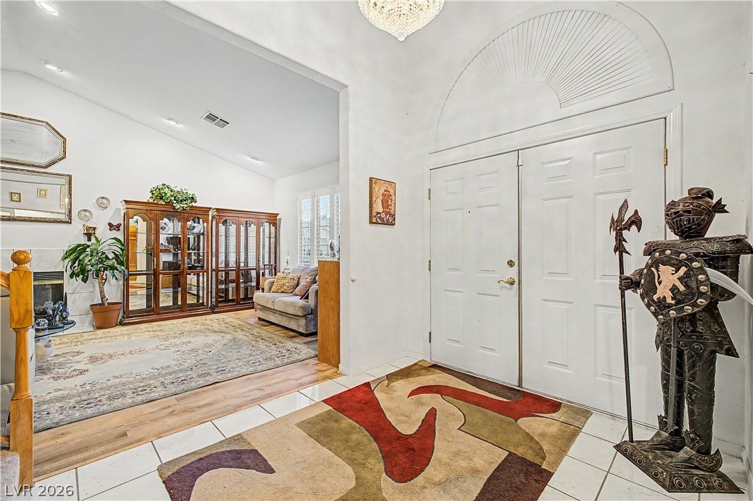 7741 Crenshaw Way, Las Vegas, NV 89129 Double doors open to a tiled foyer leading into a living area with wood flooring.