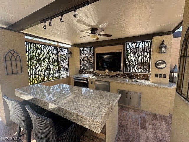8175 Arville Street, #133, Las Vegas, NV 89139 An covered outdoor cooking space features granite countertops and tiled flooring.