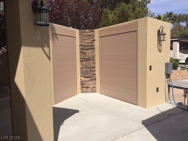 8175 Arville Street, #133, Las Vegas, NV 89139 Textured stucco and stacked stone accents frame this functional outdoor storage area with rolling doors.
