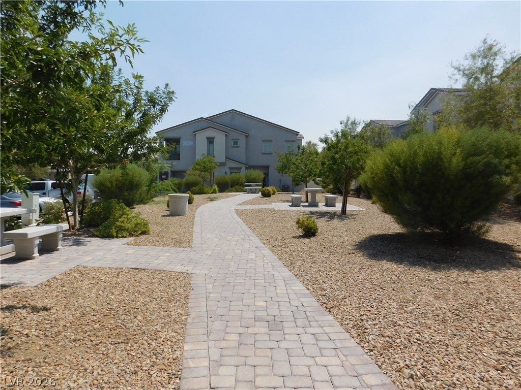 2715 Amazing Meadows Avenue, #1185, North Las Vegas, NV 89031 An inviting stone-paved walkway winds through a landscaped common area with mature desert plantings.