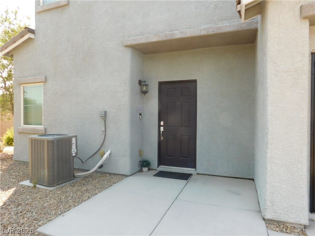 2715 Amazing Meadows Avenue, #1185, North Las Vegas, NV 89031 A sheltered concrete entryway welcomes guests to this modern stucco residence.