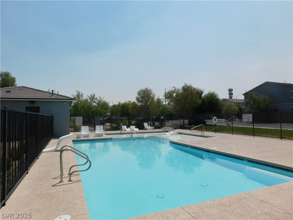 2715 Amazing Meadows Avenue, #1185, North Las Vegas, NV 89031 Fenced community swimming pool area surrounded by concrete decking and mature trees.