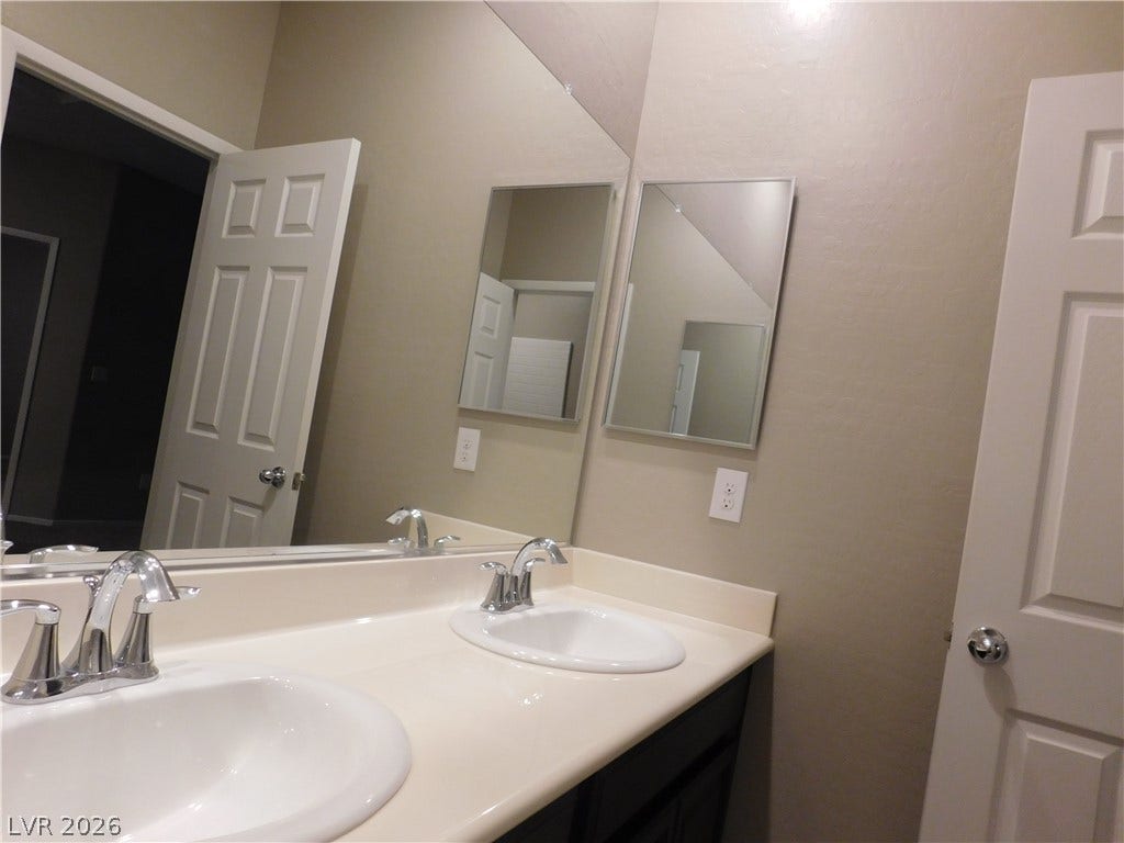 2715 Amazing Meadows Avenue, #1185, North Las Vegas, NV 89031 A spacious double vanity and large mirrors highlight this functional bathroom.