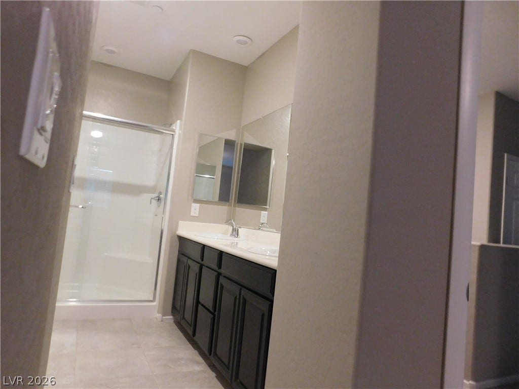 2715 Amazing Meadows Avenue, #1185, North Las Vegas, NV 89031 A spacious double vanity and enclosed shower define this functional modern bathroom space.