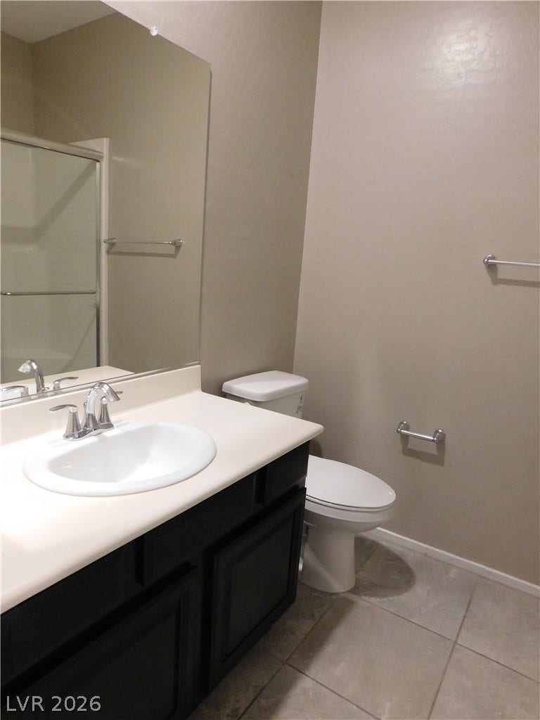 2715 Amazing Meadows Avenue, #1185, North Las Vegas, NV 89031 A classic vanity with dark cabinetry and tile flooring anchors this functional bathroom space.