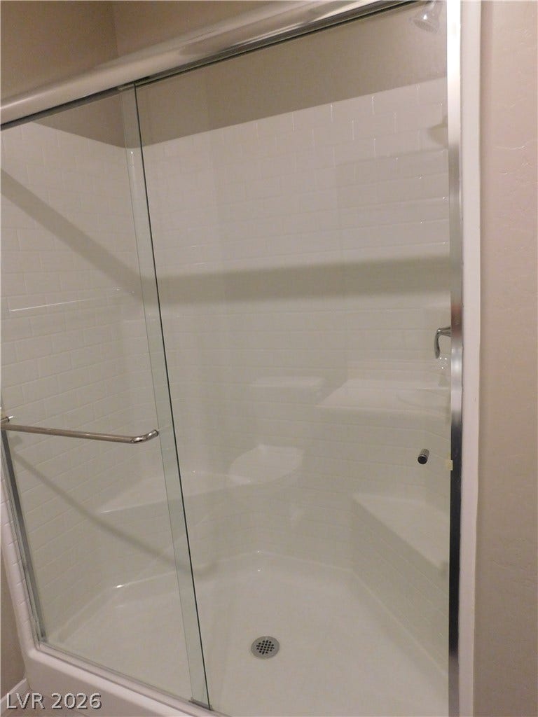 2715 Amazing Meadows Avenue, #1185, North Las Vegas, NV 89031 Crisp subway tile surrounds a spacious walk-in shower with integrated seating behind glass sliding doors.