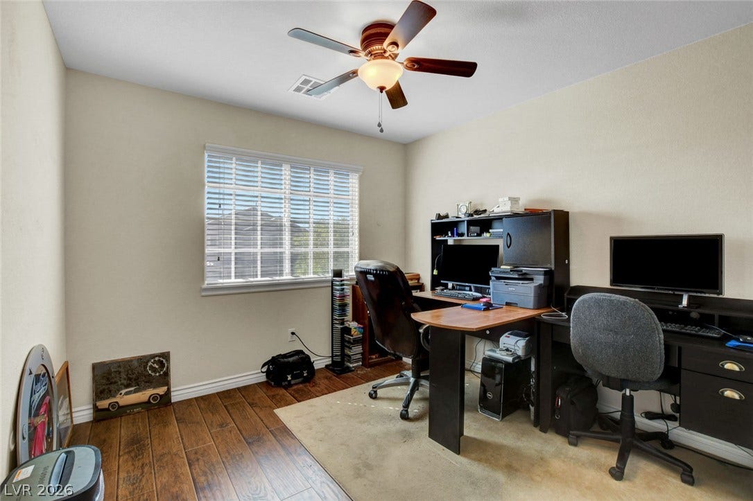 5508 Meridian Rain Street, North Las Vegas, NV 89031 Rich wood plank flooring sets a warm tone in this versatile home workspace.