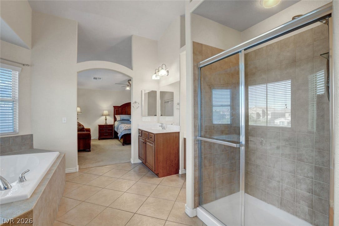 5508 Meridian Rain Street, North Las Vegas, NV 89031 Tile floors and a separate glass-enclosed shower highlight this spacious primary bathroom setup.