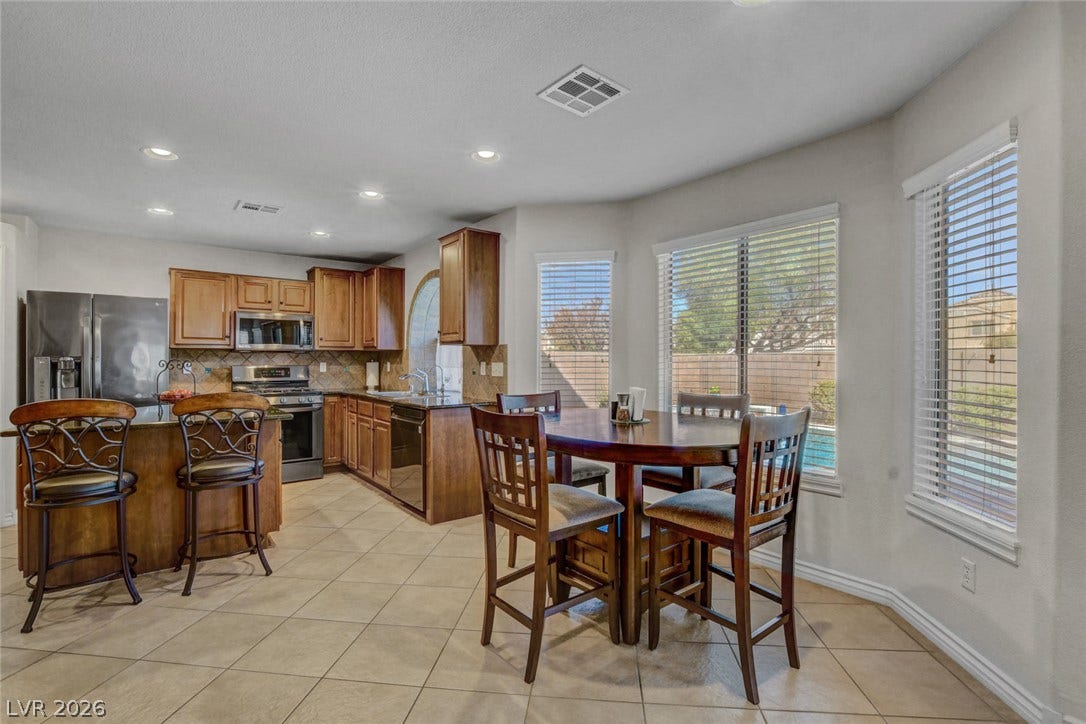 5508 Meridian Rain Street, North Las Vegas, NV 89031 Tile flooring and tall bay windows frame this inviting dining area adjacent to the kitchen.