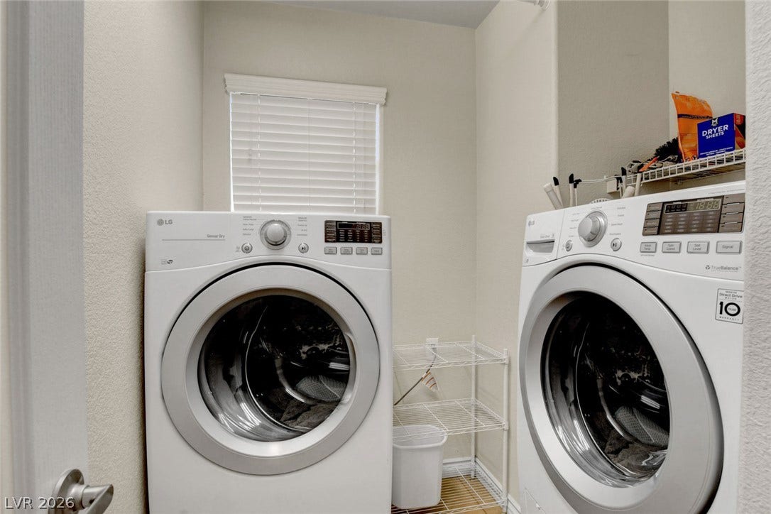 5508 Meridian Rain Street, North Las Vegas, NV 89031 A dedicated laundry utility space offers modern laundry machines and tiled flooring.