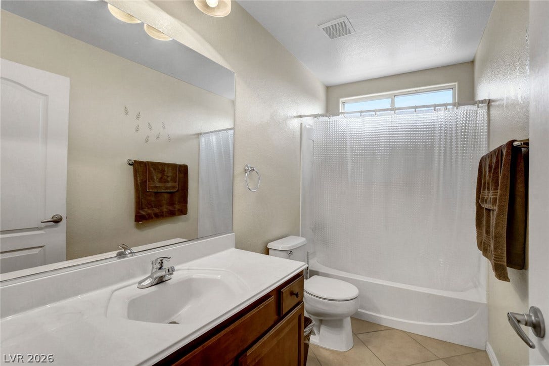 5508 Meridian Rain Street, North Las Vegas, NV 89031 A classic bathroom featuring a wood vanity and tile flooring.