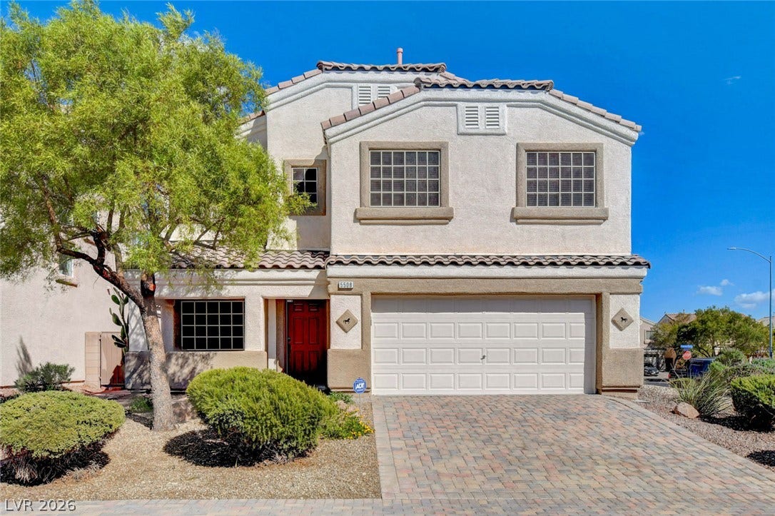 5508 Meridian Rain Street, North Las Vegas, NV 89031 Spanish tile rooflines and a paved driveway create an inviting facade under clear blue skies.
