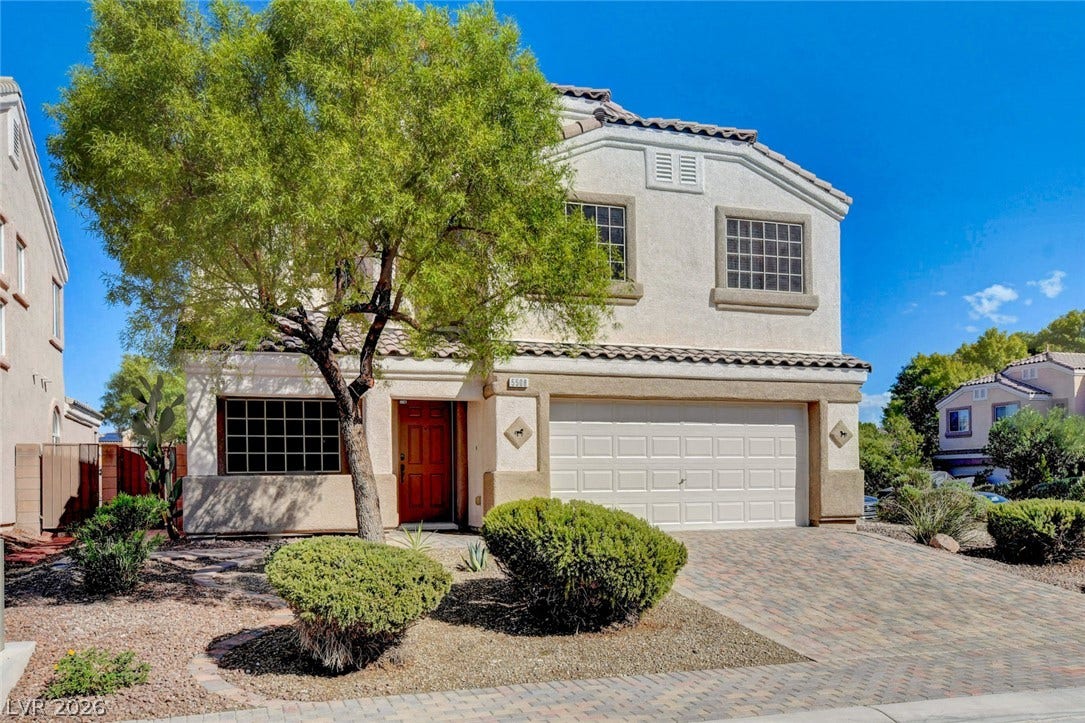 5508 Meridian Rain Street, North Las Vegas, NV 89031 A paved driveway leads to the two-car garage of this multi-level stucco home.