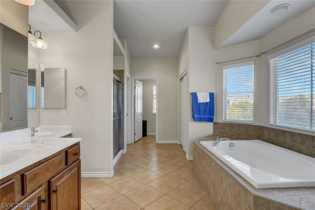 5508 Meridian Rain Street, North Las Vegas, NV 89031 A spacious bathroom features diagonal tile flooring, a large soaking tub, and double vanity.