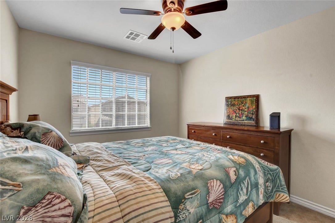 5508 Meridian Rain Street, North Las Vegas, NV 89031 Natural light pours through a large window, illuminating this comfortable and quiet bedroom.