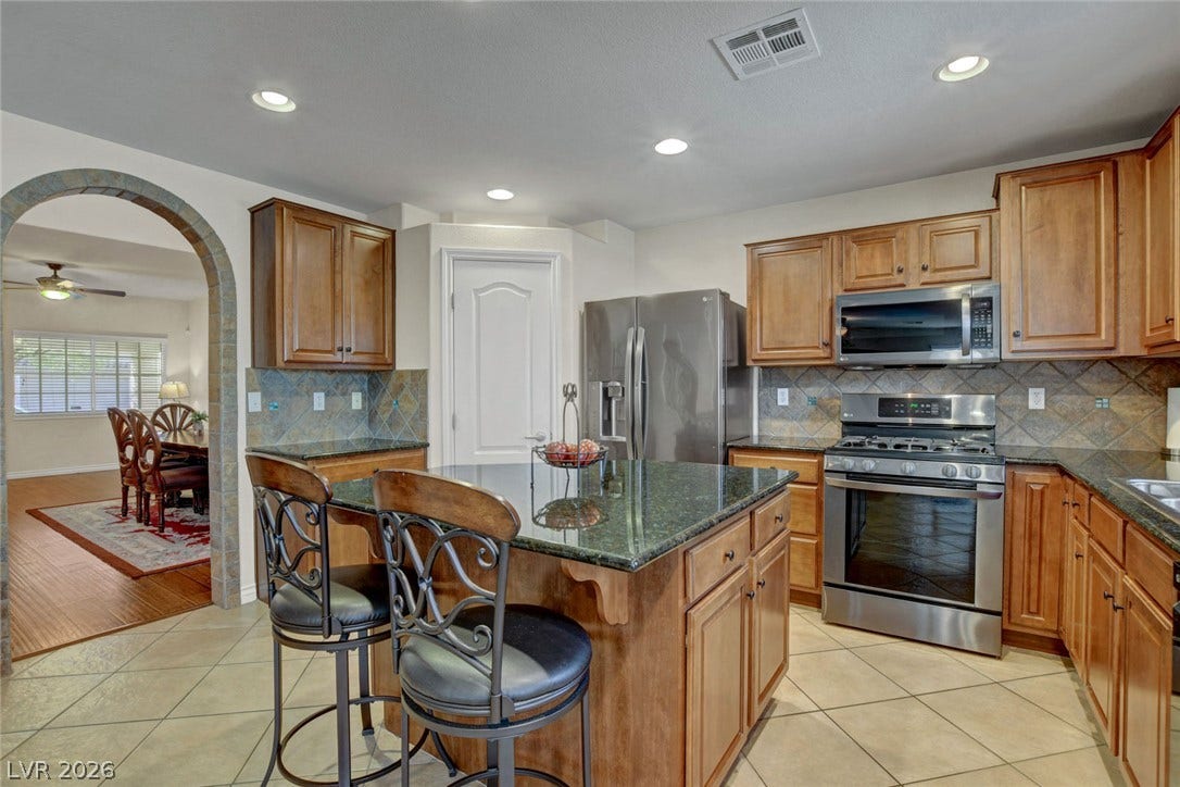 5508 Meridian Rain Street, North Las Vegas, NV 89031 Gleaming stone countertops and warm wood cabinetry define this inviting kitchen space.