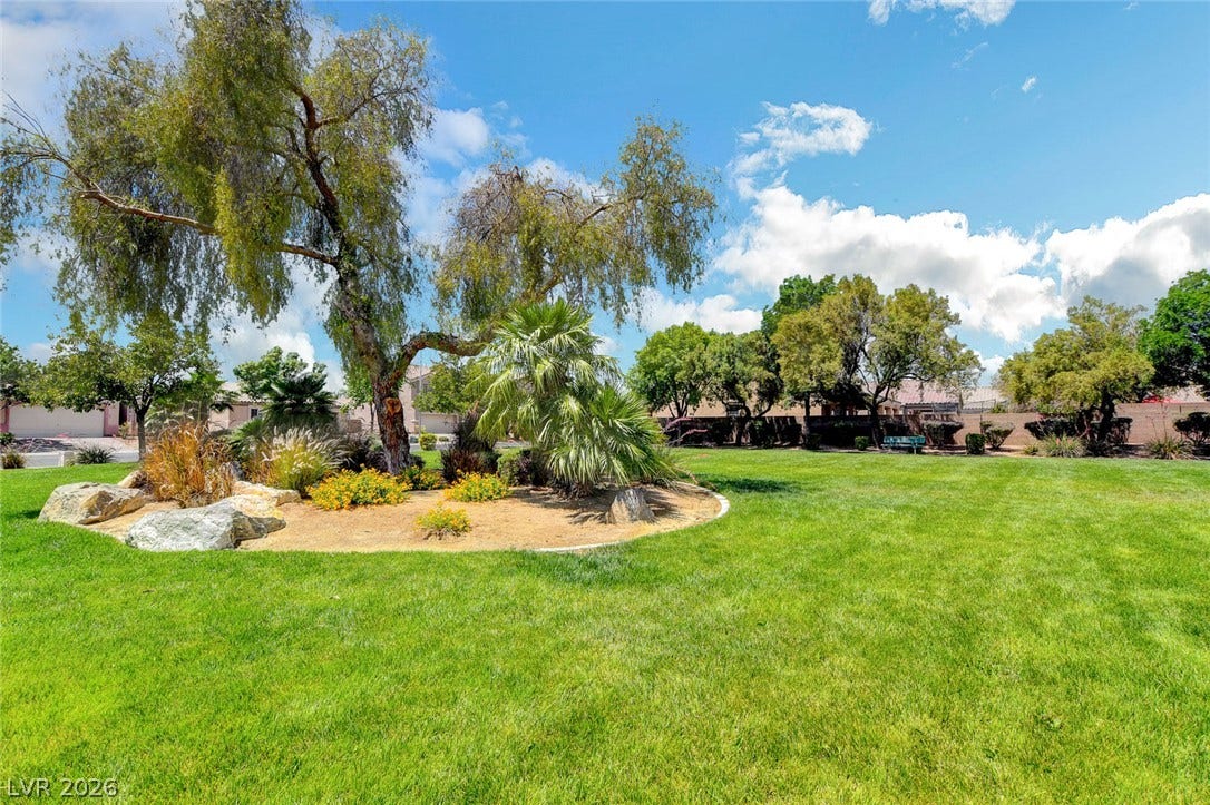 5508 Meridian Rain Street, North Las Vegas, NV 89031 Mature trees and landscaping borders a manicured lawn under clear skies.